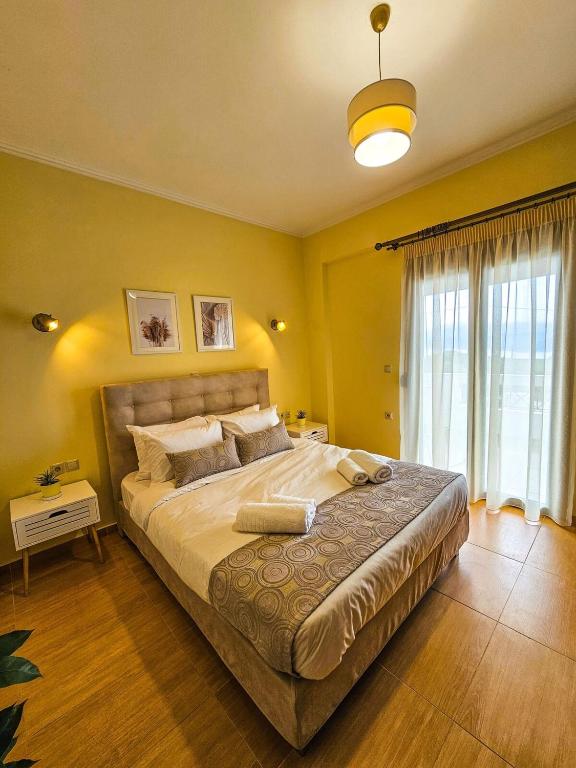 a bedroom with a large bed and a large window at Villa Aitheras with sea views and garden in Stérnai