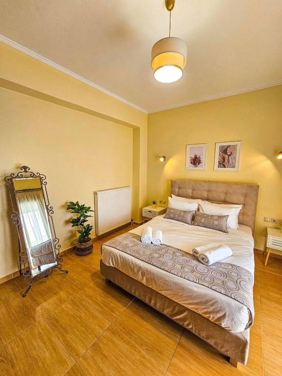 a bedroom with a large bed and a mirror at Villa Aitheras with sea views and garden in Stérnai