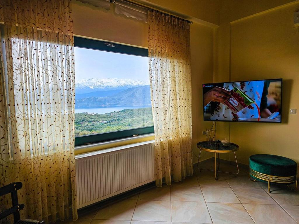 a room with a large window with a mountain view at Villa Aitheras with sea views and garden in Stérnai