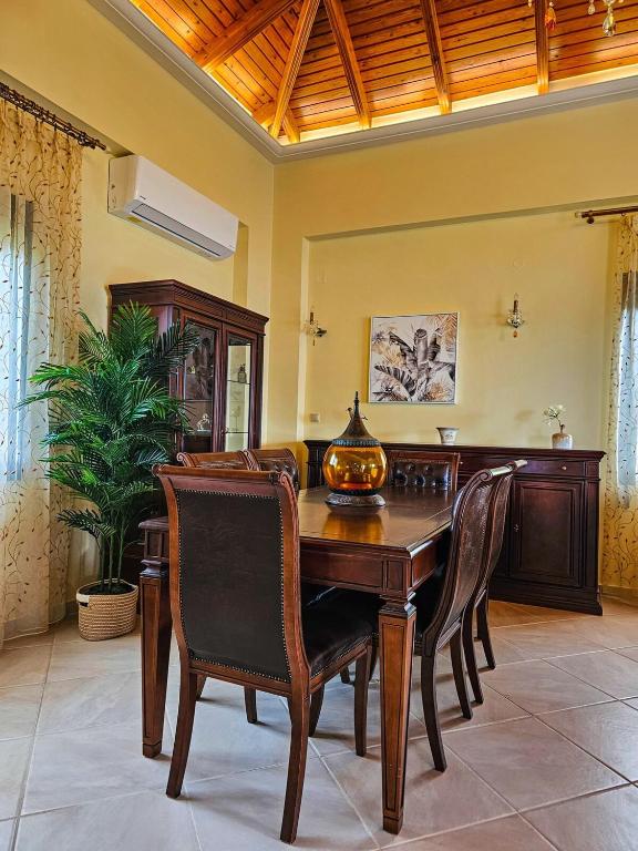 a dining room with a wooden table and chairs at Villa Aitheras with sea views and garden in Stérnai