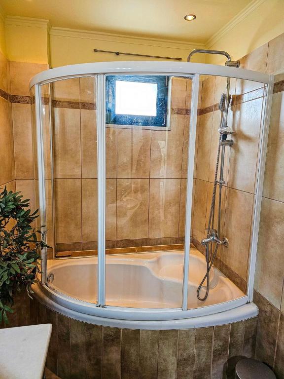 a shower in a bathroom with a tub at Villa Aitheras with sea views and garden in Stérnai