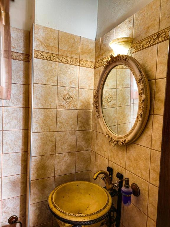 a bathroom with a sink and a mirror at Villa Aitheras with sea views and garden in Stérnai