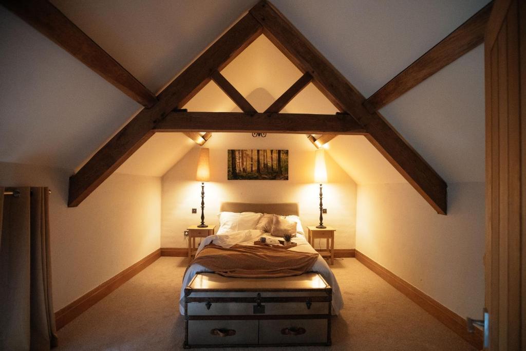 an attic bedroom with a bed and two lights at Hornington Lodge in York