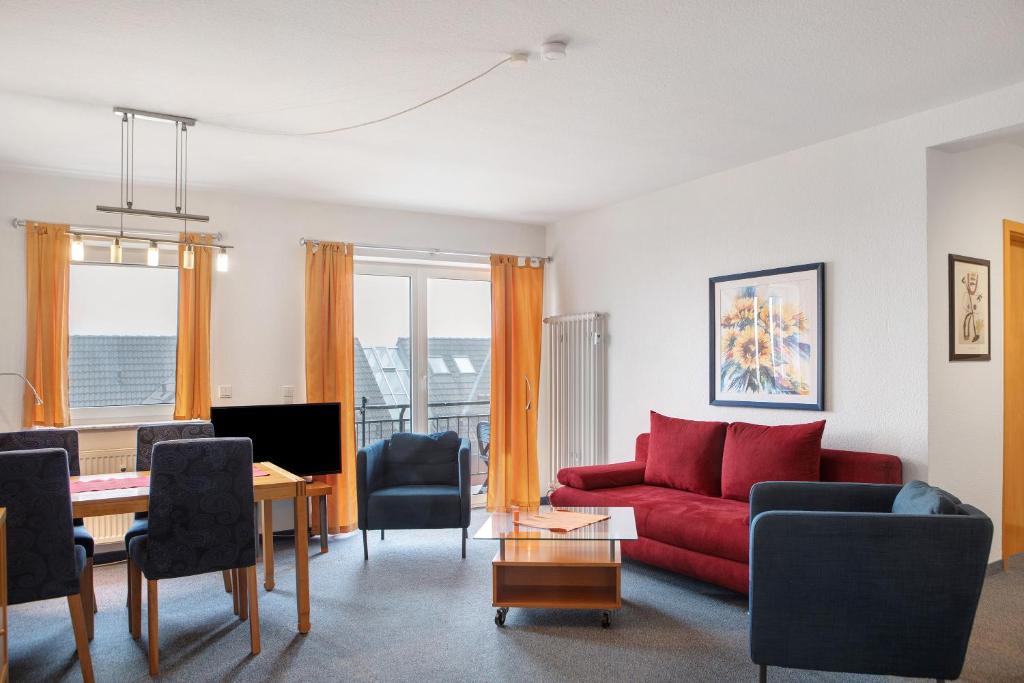 a living room with a red couch and a table at Ferienwohnung Tannenblick 2-4 in Oberhof