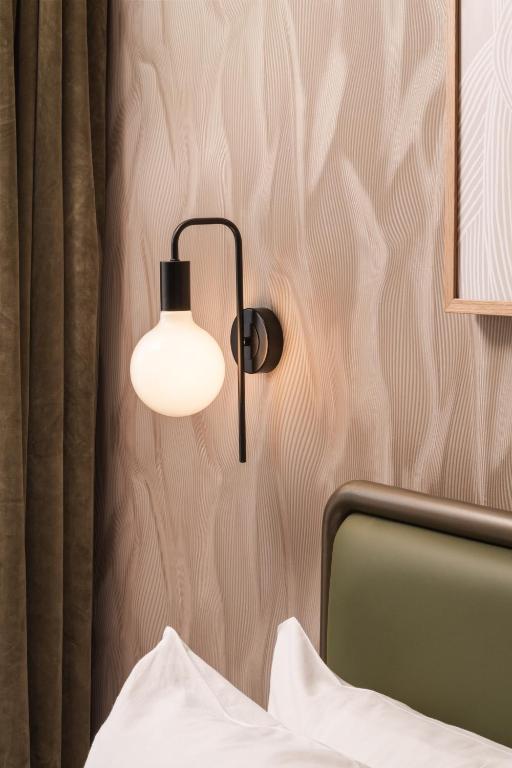 a lamp on a wall next to a bed at Central Park Hotel in London