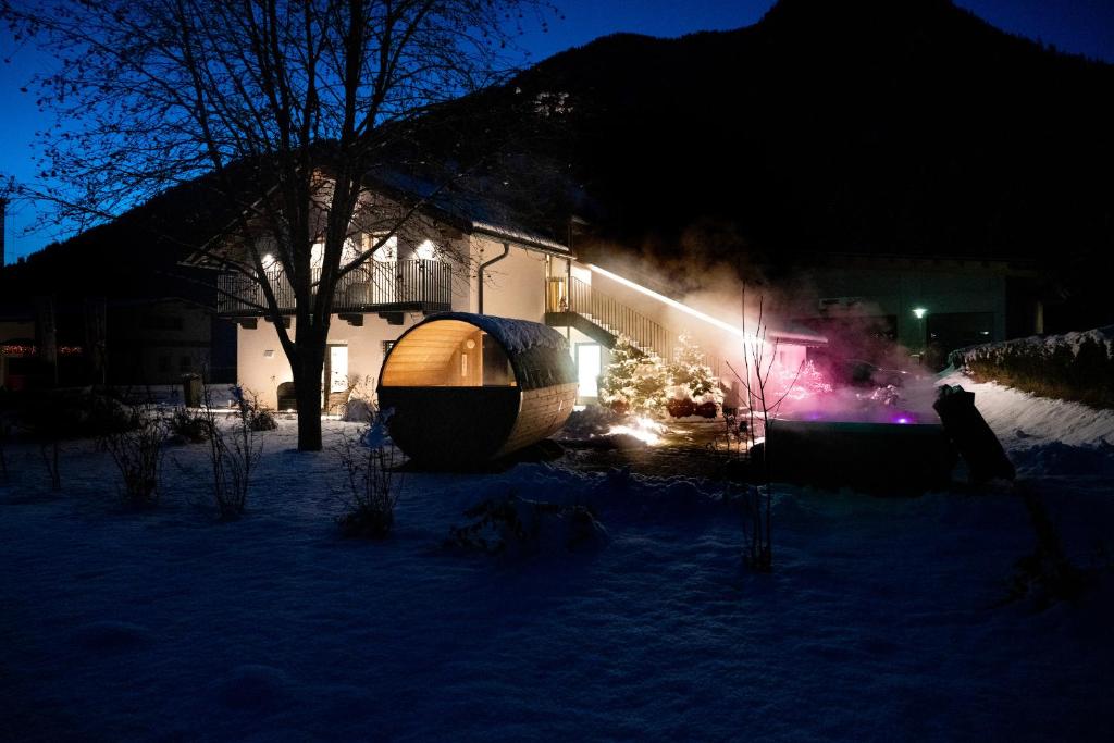 PrateriaApartments Hofmann的雪覆盖的院子,晚上在房子前面有冰屋