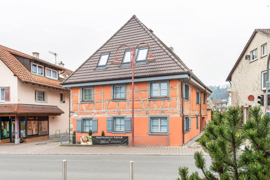 an orange building with a black roof on a street at Apartments im Gästehaus Krone in Bodman-Ludwigshafen