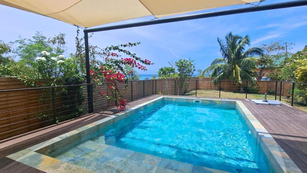 a swimming pool in a backyard with an umbrella at Moorea - Villa Pool & Chill in Maharepa
