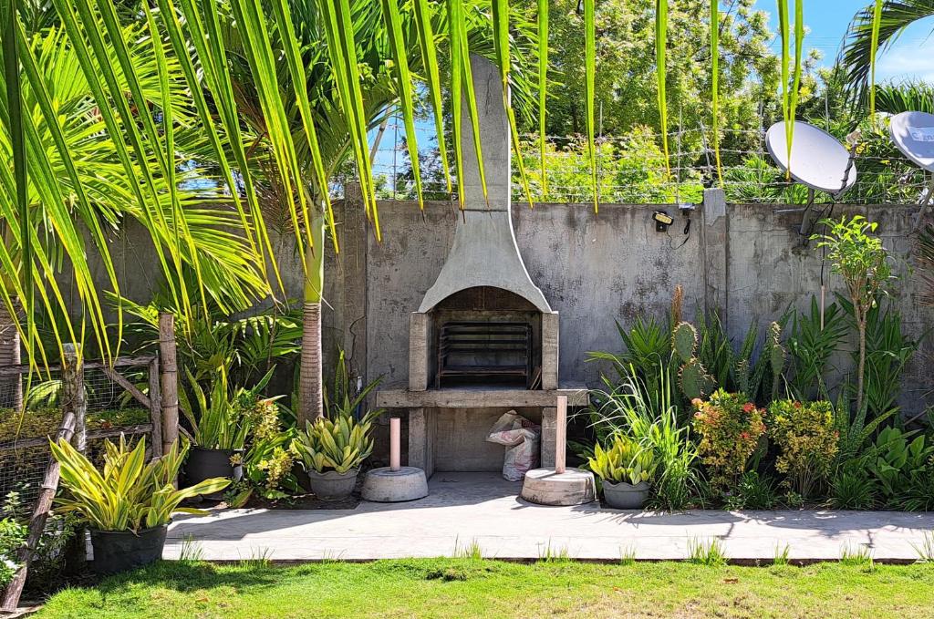 un forno all'aperto in un giardino con piante di Mirka's Guest House a Isola di Bantayan