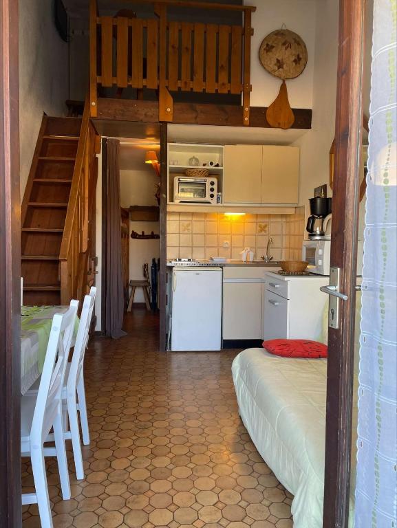 Il comprend une cuisine avec un escalier et des appareils électroménagers blancs. dans l'établissement SP310-093 Maison studio cabine mezzanine SAINT PIERRE LA MER, à Saint Pierre La Mer