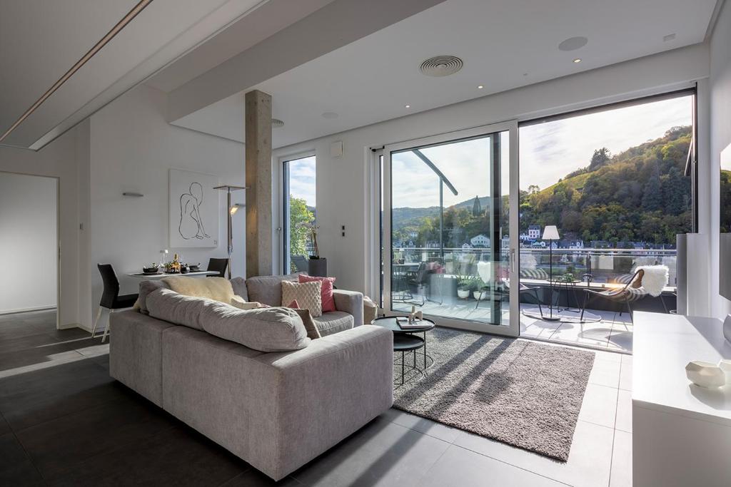 Una sala de estar con un sofá y una ventana grande. en Neu PENTHOUSE MoselTop Luxus Design Klima 2P, en Traben-Trarbach