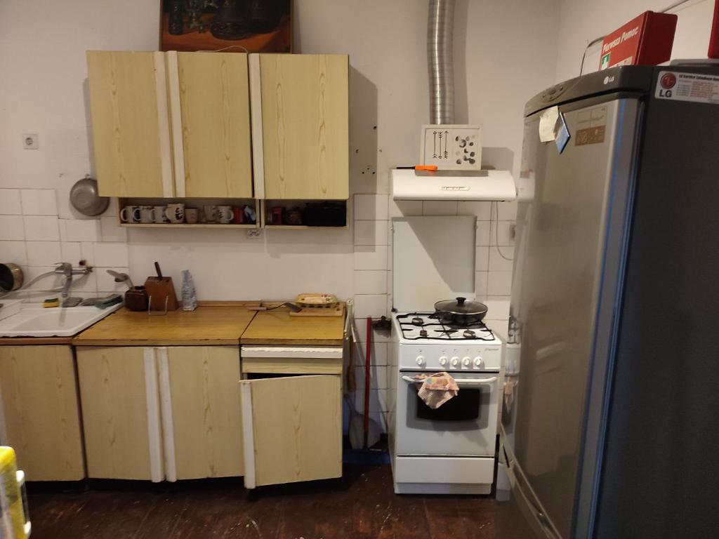 a kitchen with a stove and a refrigerator at Biały dom Cyprysowa 11 in Warsaw
