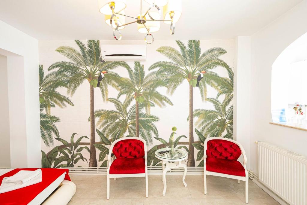 een woonkamer met palmbomen muurschildering op de muur bij Apartament Faleza in Galaţi