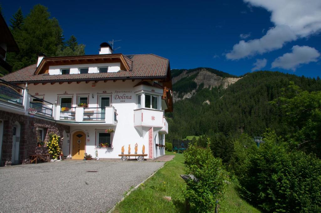 Casa blanca con balcón en una montaña en Apartments Dolina, en Ortisei