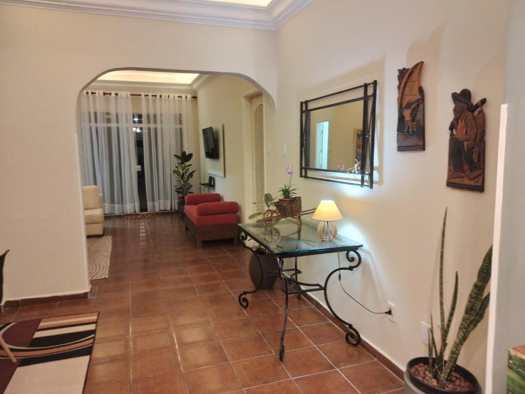 een woonkamer met een rode bank en een tafel bij Cobertura com churrasqueira São Vicente in São Vicente