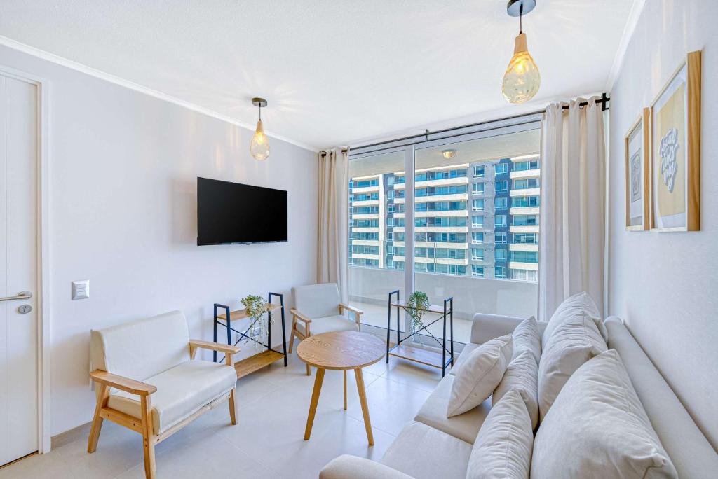 a living room with a couch and a tv at Vista Infinita in Concón