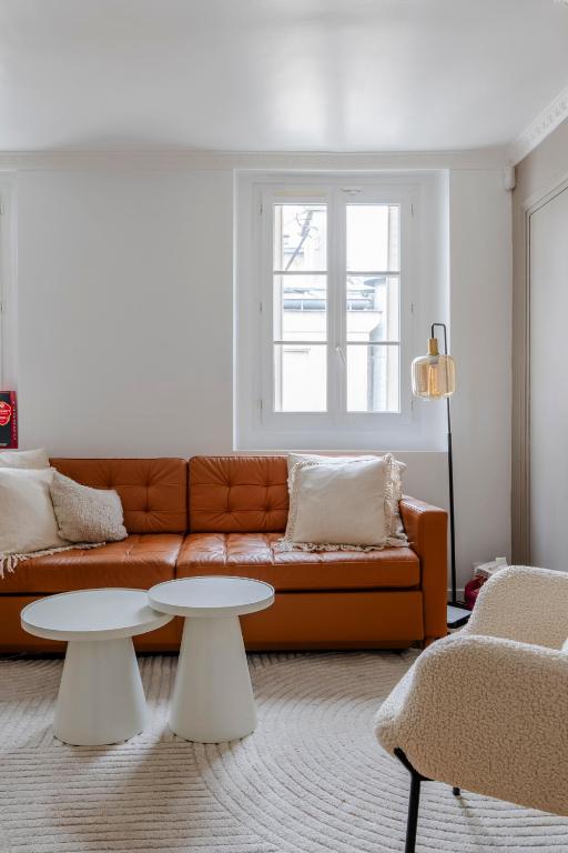 un salon avec un canapé et deux tables dans l'établissement Veeve - Earthy Serenity, à Paris