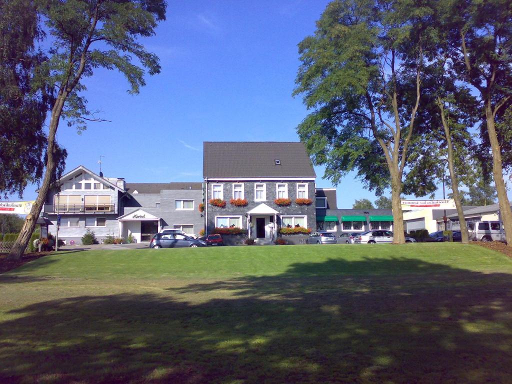 ein großes Haus mit großem Rasen davor in der Unterkunft Hotel Restaurant Fischer in Remscheid