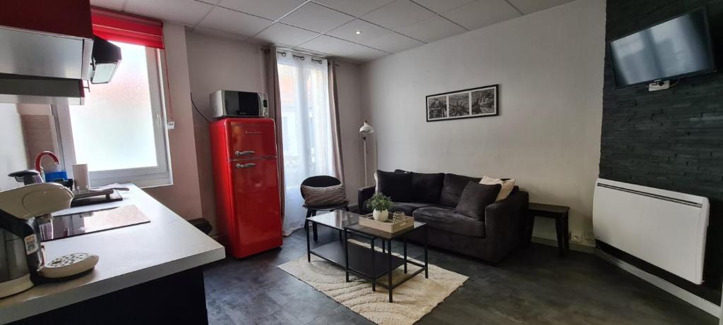 - un salon avec un canapé et un réfrigérateur rouge dans l'établissement L'Urban Clignancourt - Bel appartement tout équipé aux Portes de Paris, à Saint-Ouen