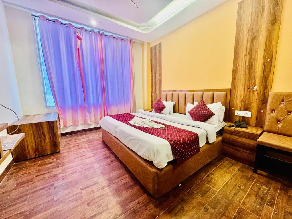 una camera da letto con un letto e una grande finestra di The Royal Residence Inn a Manāli