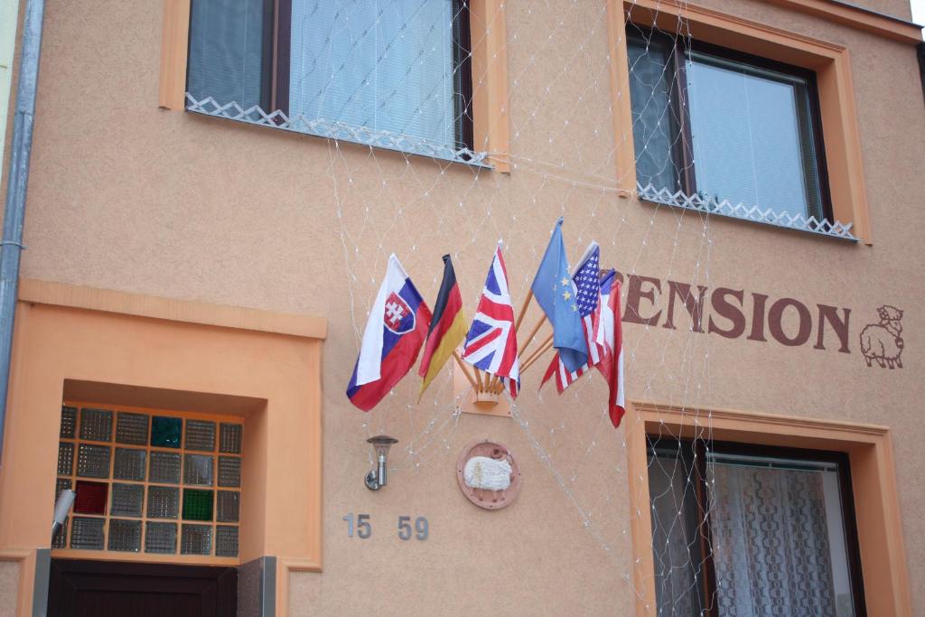 um grupo de bandeiras penduradas do lado de um edifício em Pension Beránek em Praga