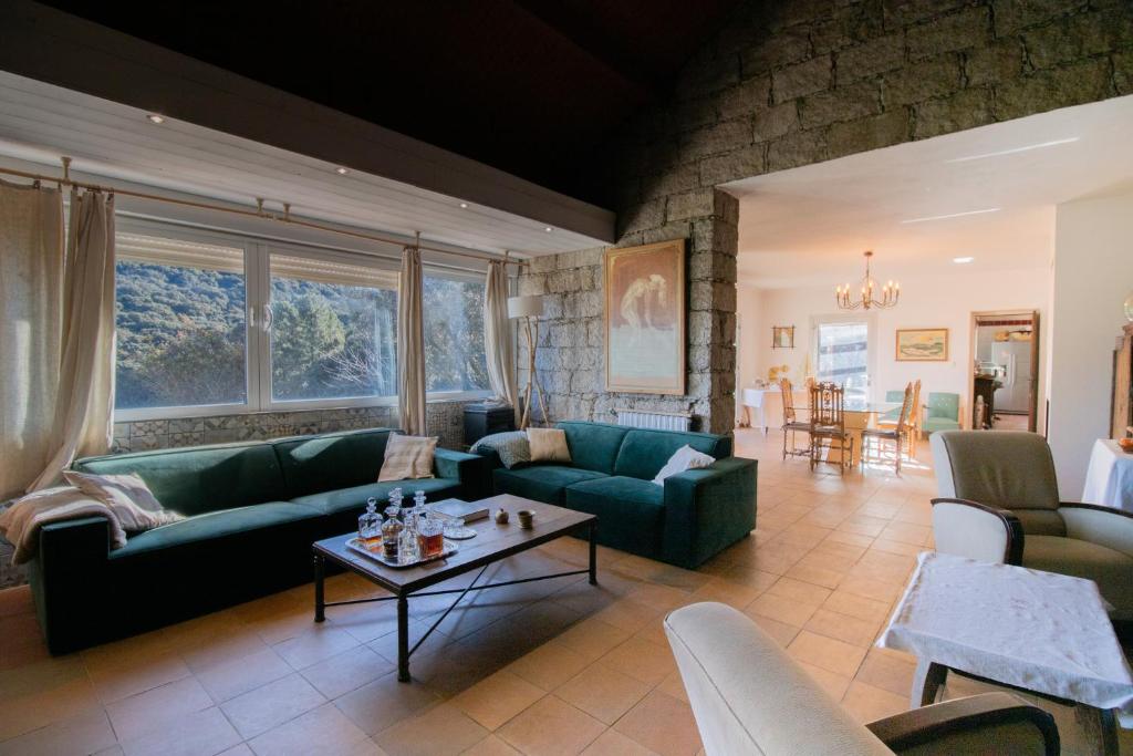 un salon avec des canapés verts et une table dans l'établissement Chez Jean Viti, à Levie