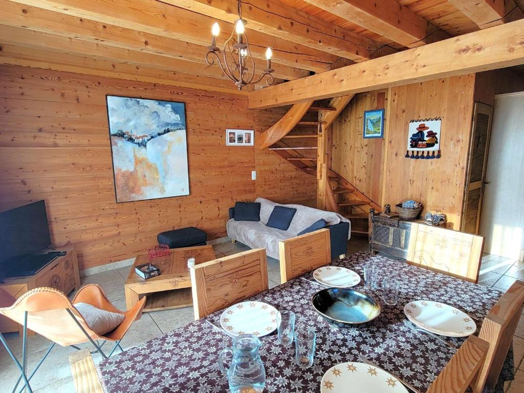 a living room with a table in a cabin at Chalet en bois 6 pers. avec terrasse Sud, lumineux et équipé, animaux admis – Saint-Michel-de-Chaillol - FR-1-393-12 in Saint-Michel-de-Chaillol