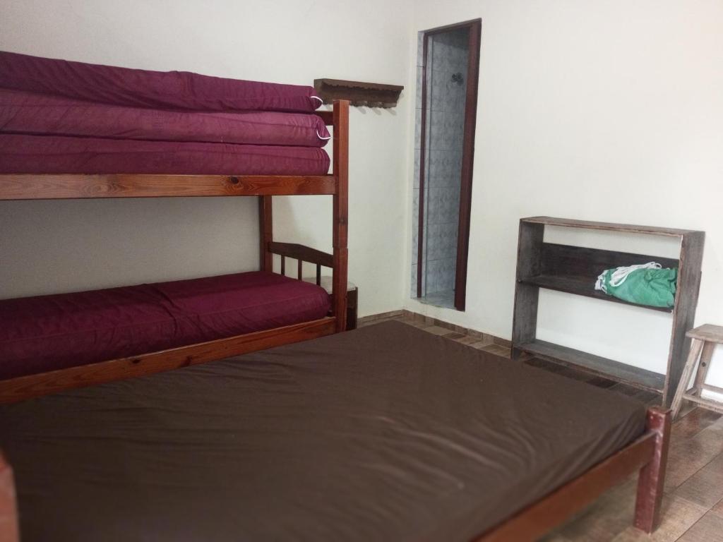 a room with two bunk beds and a mirror at Ap. Duplex Praia grande Ubatuba in Ubatuba