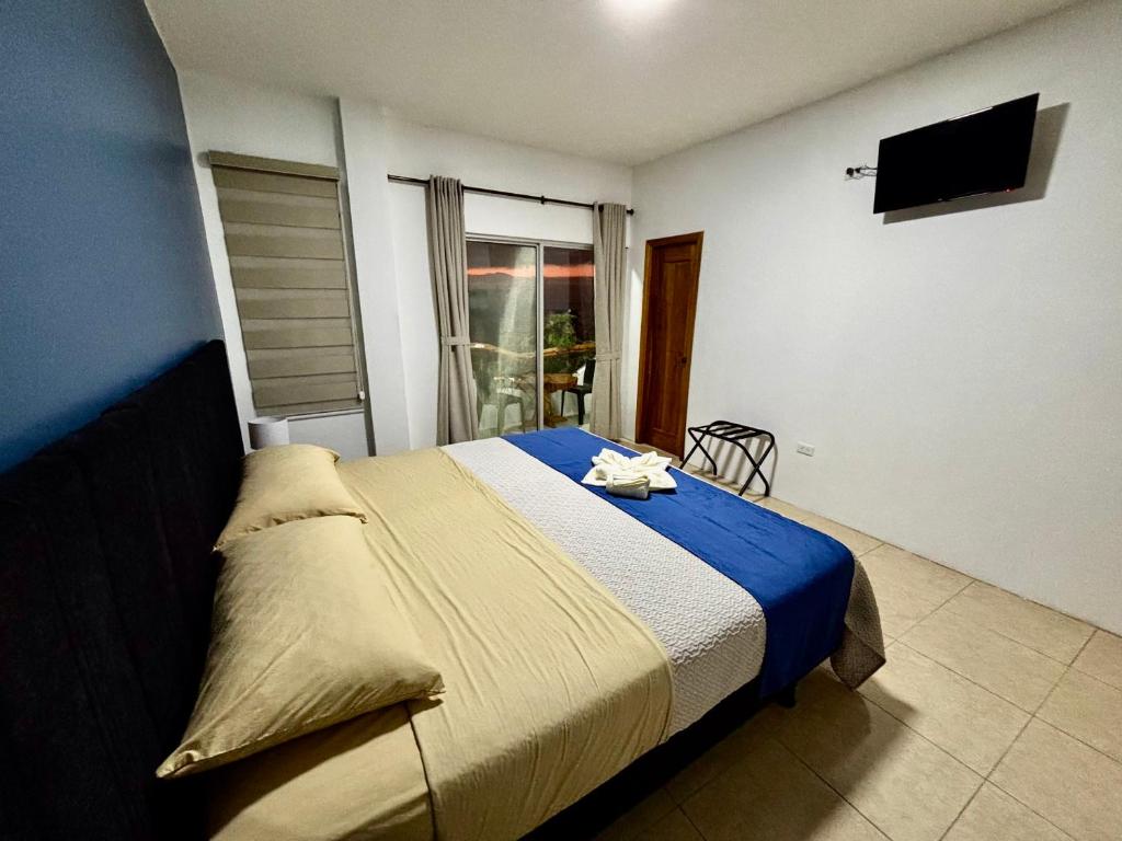 Un dormitorio con una cama y un televisor. en Suite Arena, a pocos metros de la playa, en Puerto Baquerizo Moreno