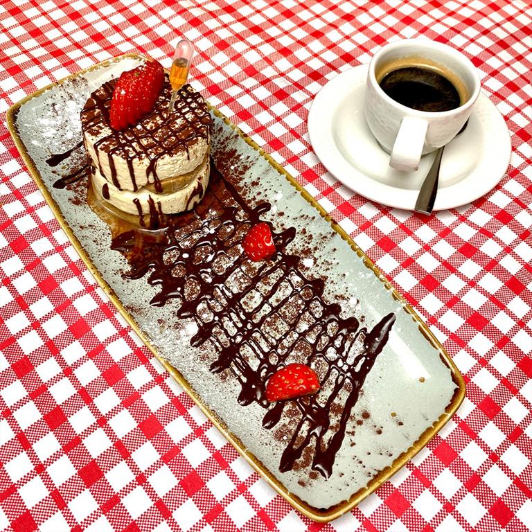 a plate with a piece of cake and a cup of coffee at Harbour Heights Hotel in Poole