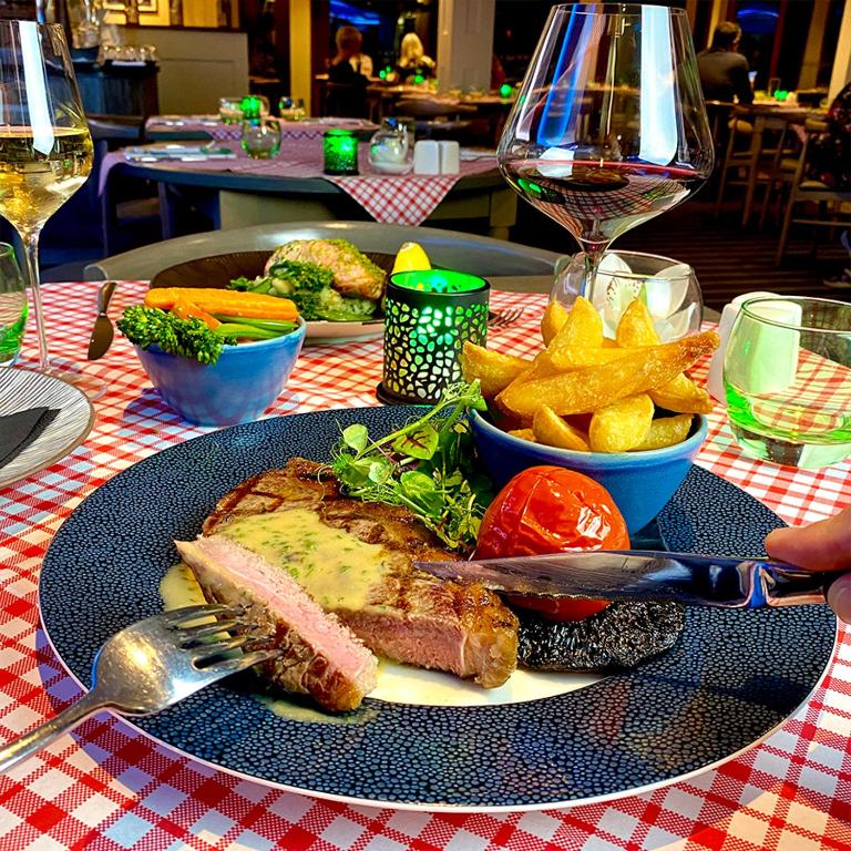 a plate of food with meat and chips on a table at Harbour Heights Hotel in Poole