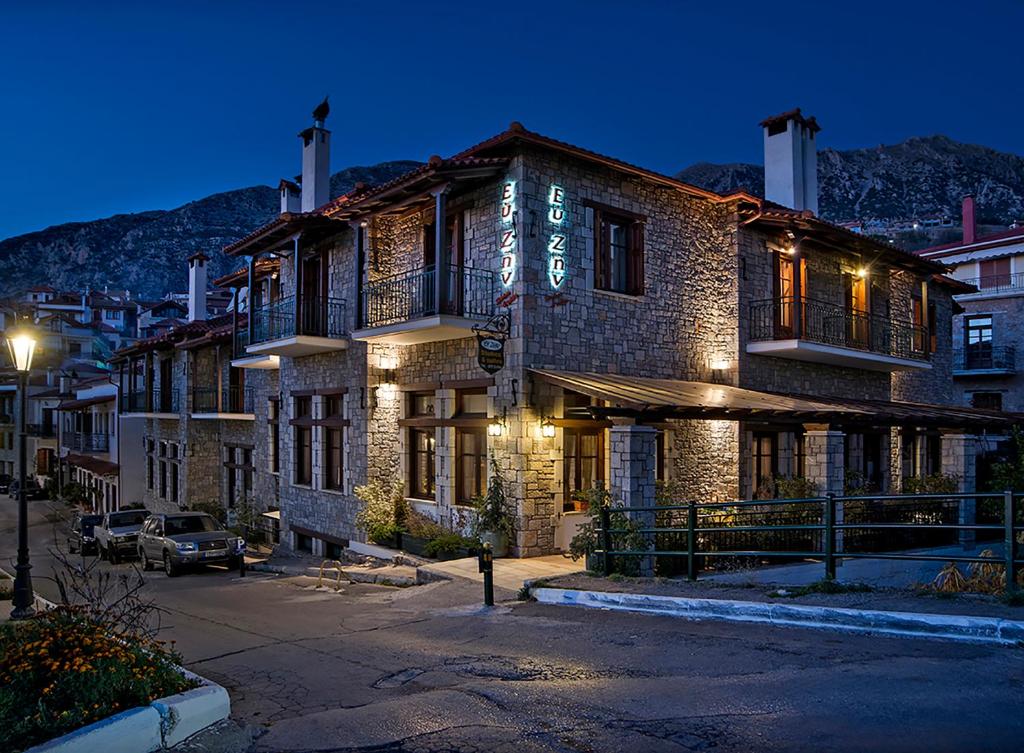 un bâtiment avec un panneau sur son côté la nuit dans l'établissement Ef Zin Hotel Arachova, à Arachova