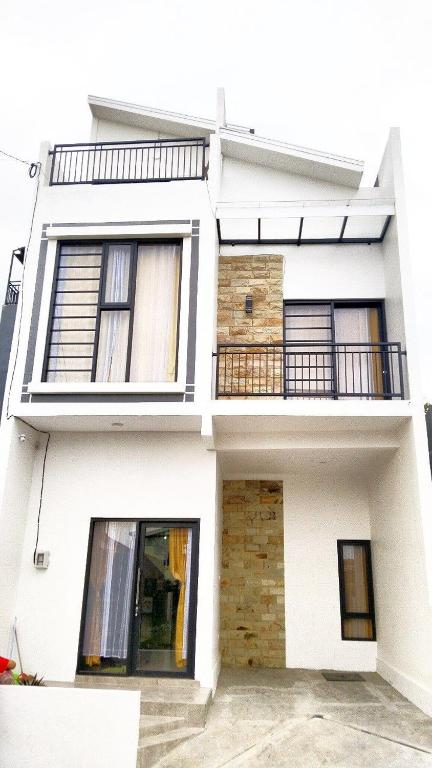 a white house with windows and a balcony at Vila Alief Batu in Tlekung