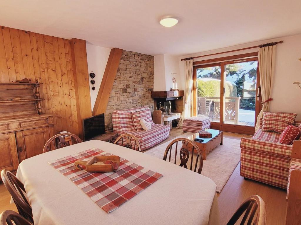 un salon avec une table et des chaises et une cheminée dans l'établissement Appartement cosy 2 ch. à Megève - Terrasse, Piscine, Parking, Proche Centre - FR-1-453-222, à Megève