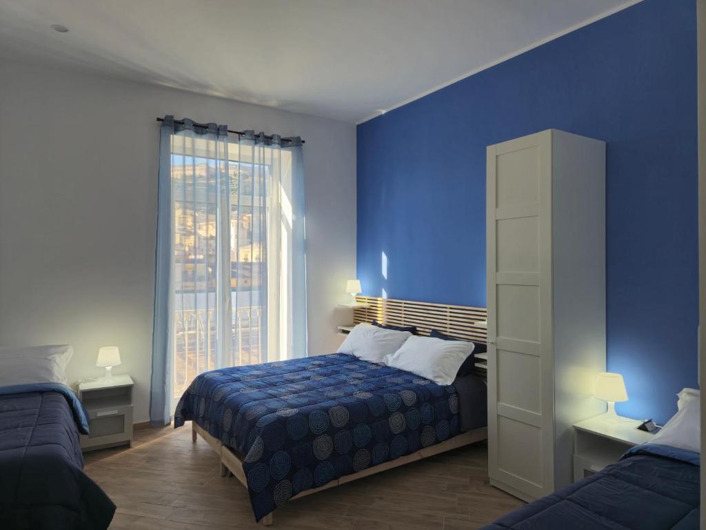 a blue bedroom with a bed and a window at Appartamento Annunziata in Naples