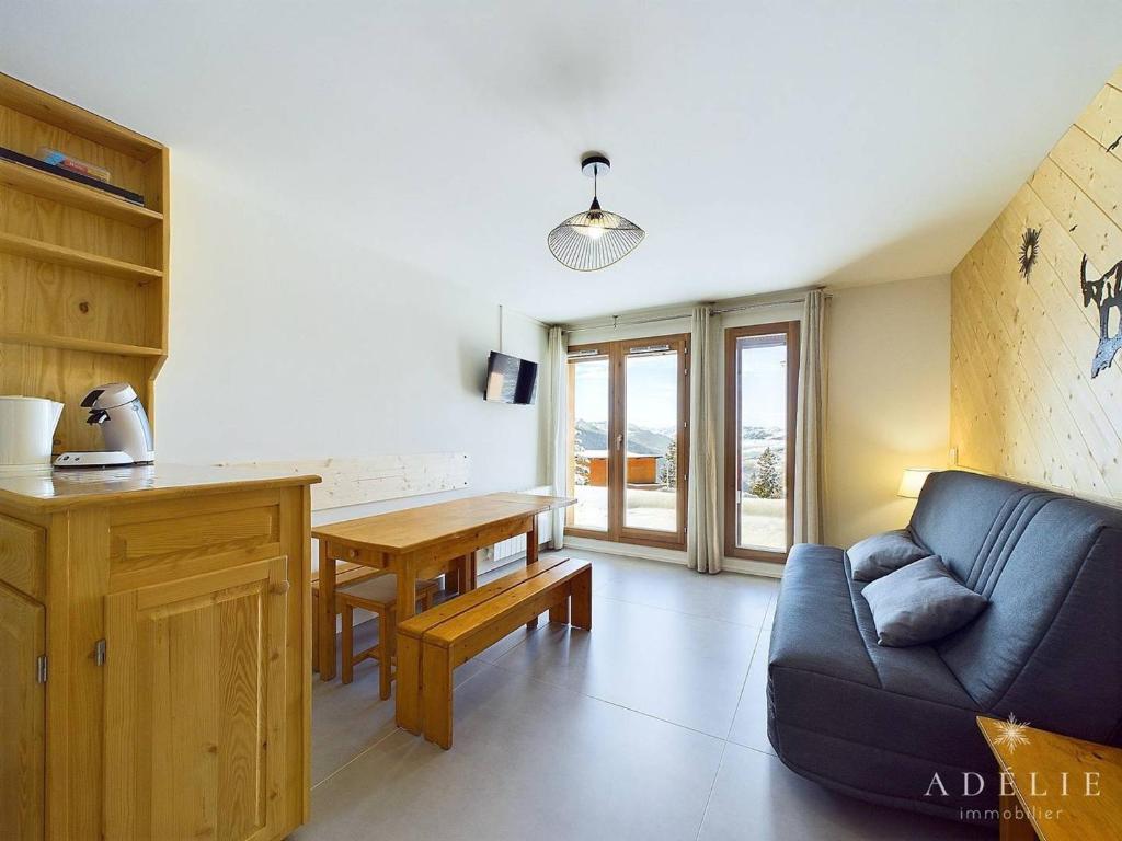 un salon avec un canapé bleu et une table dans l'établissement Studio spacieux rénové, exposition sud, proche des pistes - FR-1-398-669, à Montvalezan