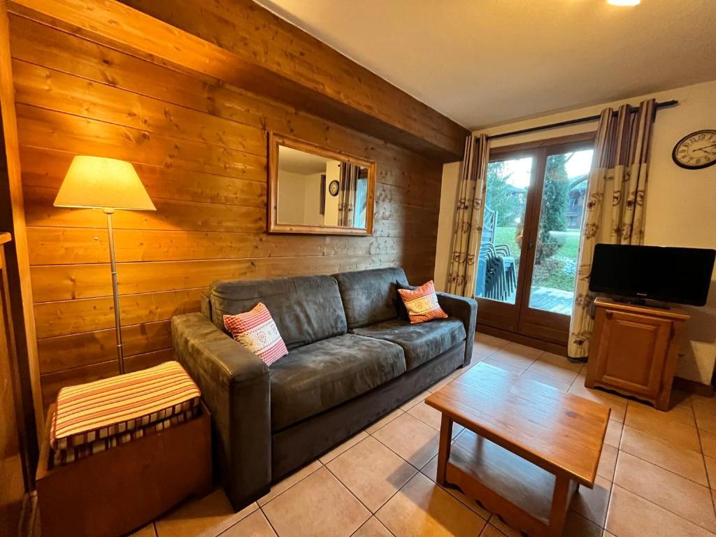 un salon avec un canapé en cuir et une table dans l'établissement Appartement triplex avec piscine, parking, animaux acceptés - FR-1-624-169, à Samoëns