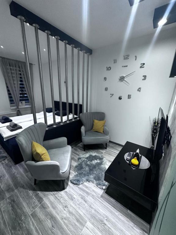 a living room with a couch and a clock on the wall at Apartment SaGo in Clausthal-Zellerfeld