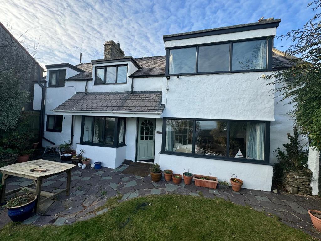 a white house with a table in the yard at Bryn Teg Cottage in Moelfre