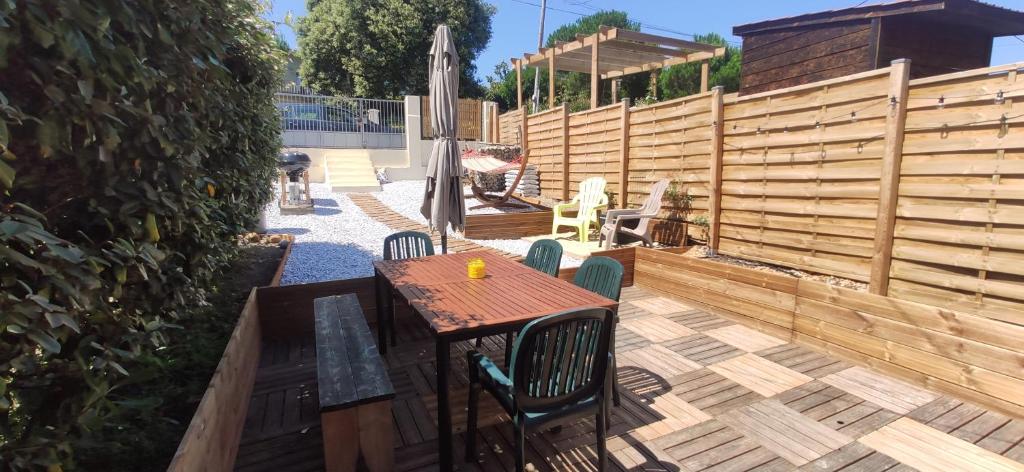 un patio avec une table et des chaises et une clôture dans l'établissement Soulac, à 150m de la plage et proche centre-ville maison 8 personnes, à Soulac-sur-Mer