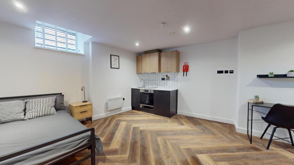 a living room with a bed and a kitchen at The Thurloe Studios in Manchester
