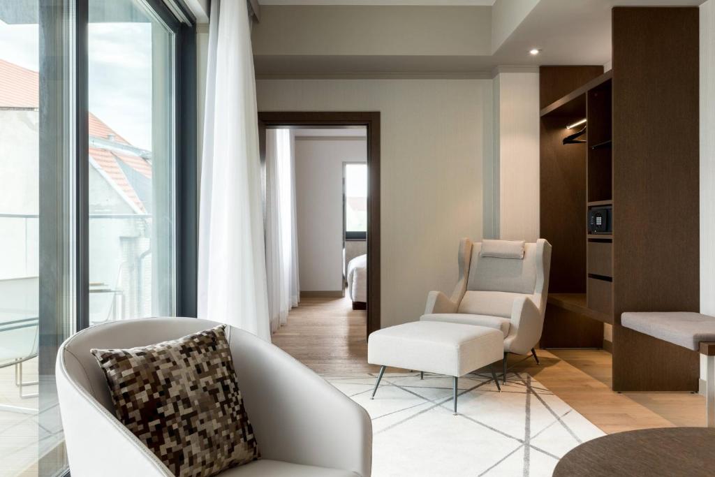 a living room with a white chair and a couch at AC Hotel by Marriott Wroclaw in Wrocław