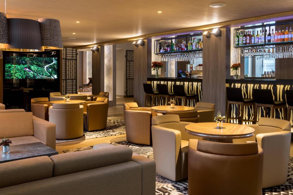 a restaurant with tables and chairs and a bar at AC Hotel by Marriott Wroclaw in Wrocław