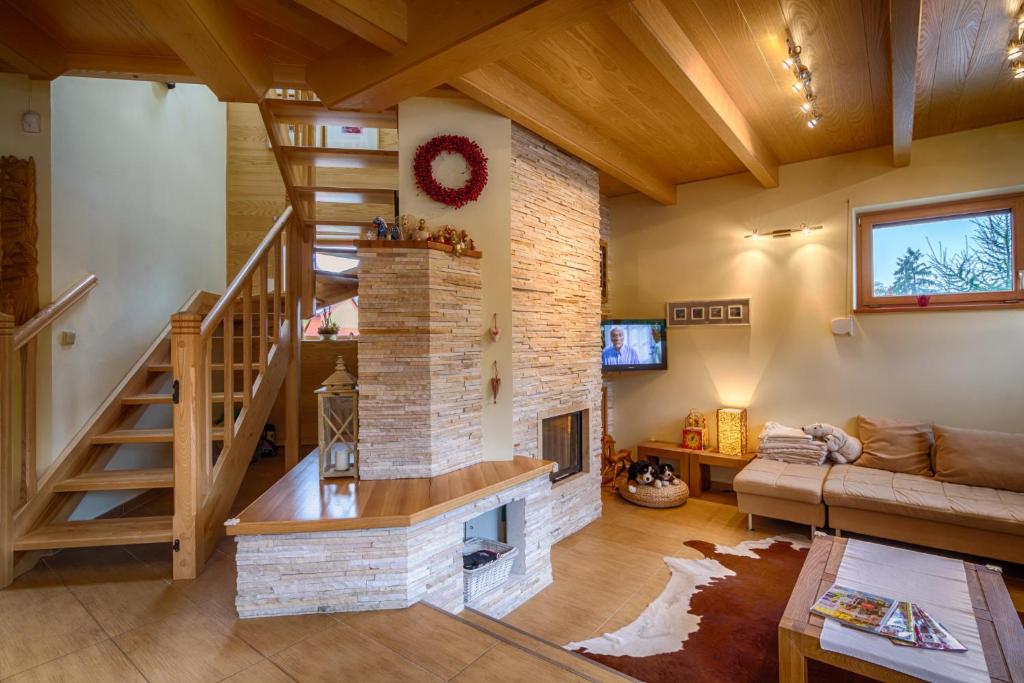 a living room with a staircase and a fireplace at Vila Studienka in Starý Smokovec