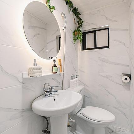 a bathroom with a sink and a toilet and a mirror at Noddle Sun Stay in Seoul
