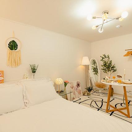 a white bedroom with a bed and a table at Noddle Sun Stay in Seoul