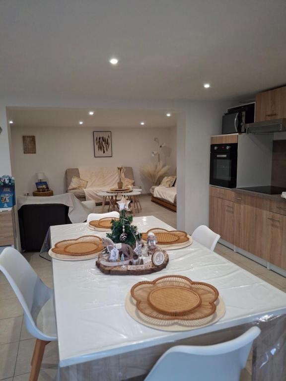 a living room with a table with chairs and a kitchen at Les châtillonnes 25 minutes du zoo de beauval in Châtillon-sur-Indre