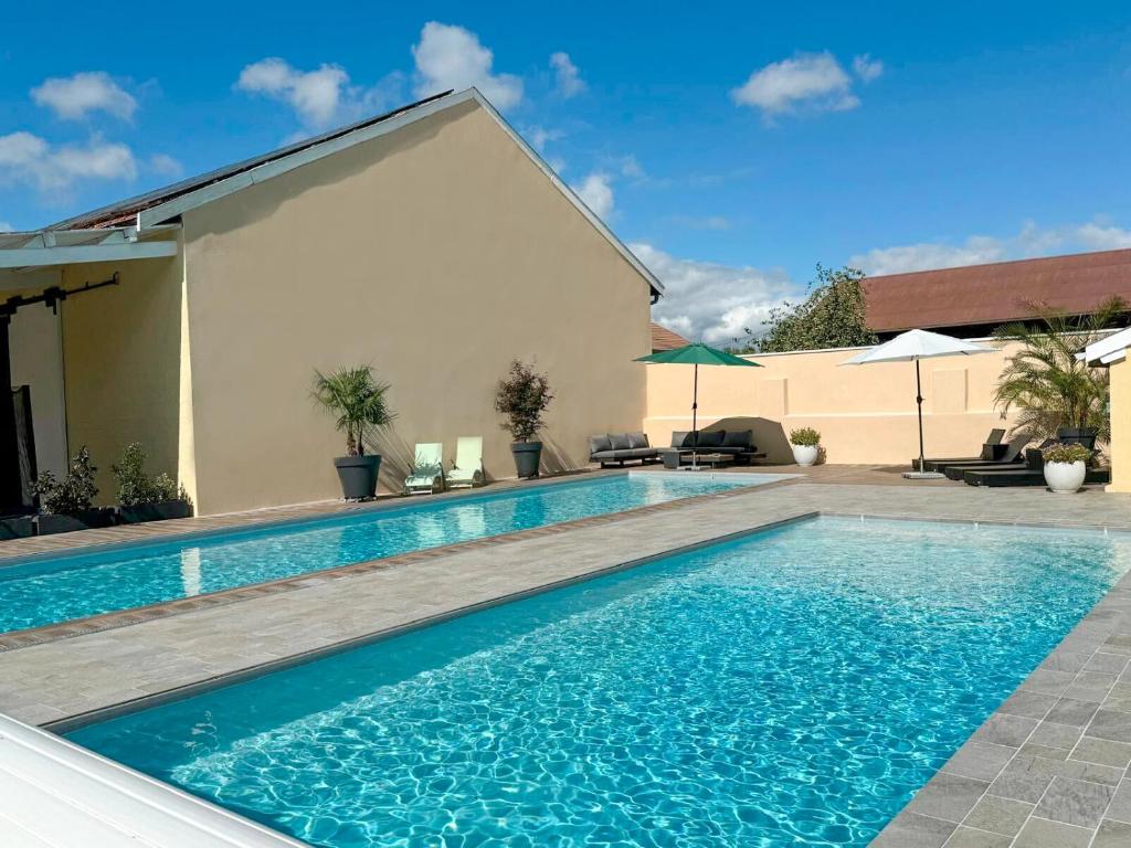 a swimming pool in front of a house at L'Artbanne - Maison Gaïa in Saint-Hilaire-le-Petit