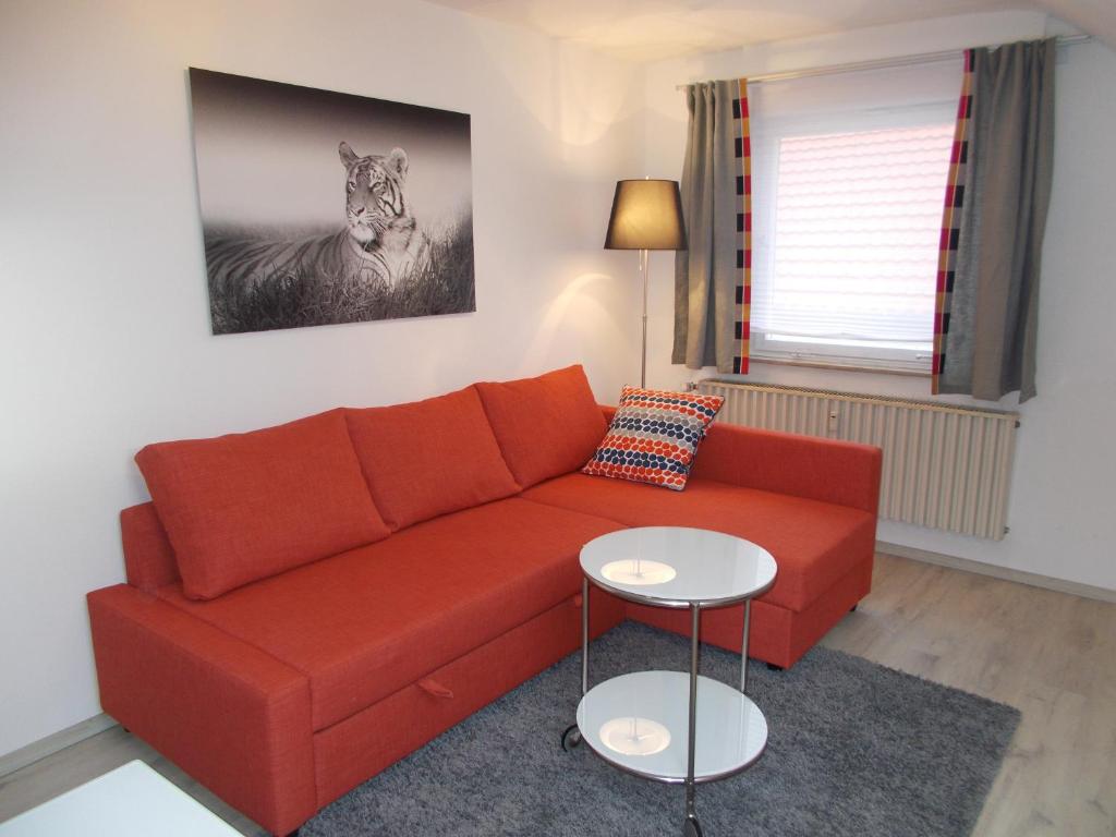 a living room with a red couch and a picture of a zebra at Apartment Seven Ducks in Aalen