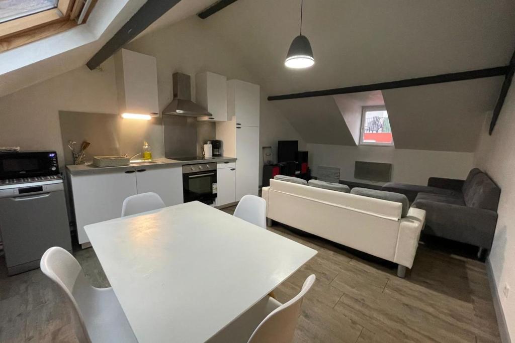 une cuisine et un salon avec une table et des chaises blanches dans l'établissement La Mansardé Baheux, au Havre